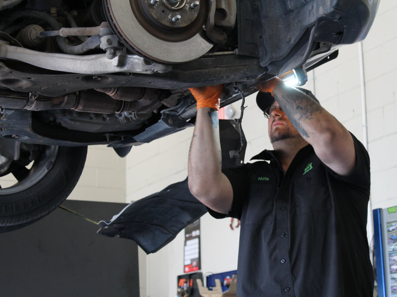 Nate working under a vehicle on the lift